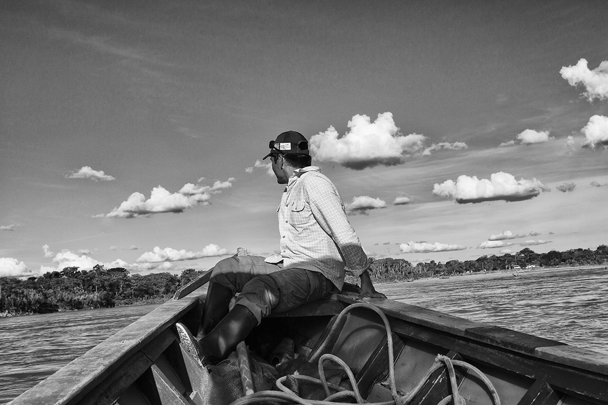 Uomo sulla prua di una barca in amazzonia